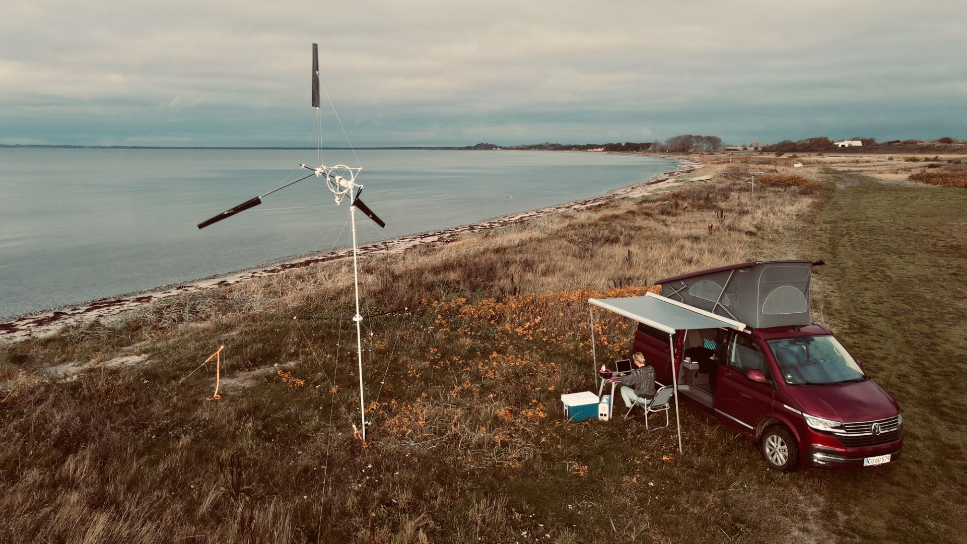 Kitex vindmølle ved siden af autocamper på en strand.