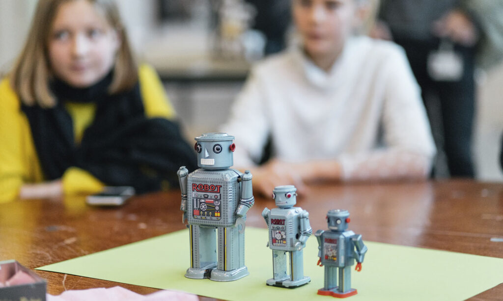 Piger sidder bag robotter til Machine Day i Spinderihallerne