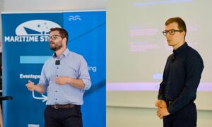 Two men presenting in front of a projector screen